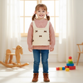 Girl wearing cream knit bow vest over dusty pink cable knit sweater with jeans